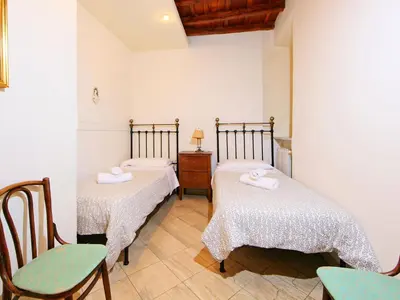 a room with two beds and a table and chairs at Apartment Vittorio Emanuele-1 by Interhome in Rome