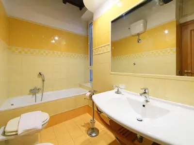 a bathroom with a sink and a tub and a mirror at Apartment Vittorio Emanuele-1 by Interhome in Rome