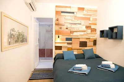 a bedroom with a bed and a wooden wall at Private Modern Studio Paolina City Center in Rome