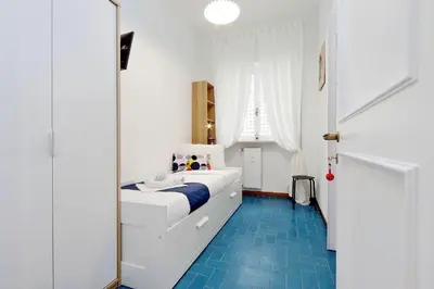 a bedroom with a white bed and a blue floor at YCH-TRASTEVERE cozy flat for 8 people in Rome