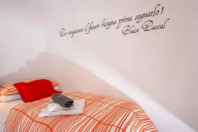 a bed with a red pillow and a bag on it at Vatican Meadows in Rome