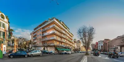 a tall building on a city street with parked cars at Vatican Meadows in Rome