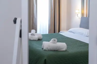 a hotel room with two beds with towels on them at Vatican Apartment Borgo Pio in Rome