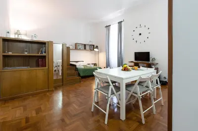 a kitchen and living room with a white table and chairs at Vatican Apartment Borgo Pio in Rome