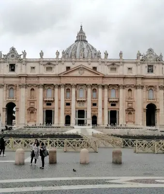 two people walking in front of a large building at Vatican Apartment Borgo Pio in Rome