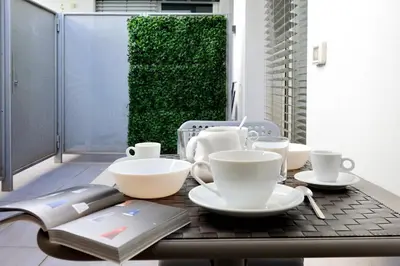 a table with cups and plates and a book on it at Piazza del Popolo Apartment in Rome