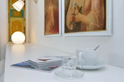 a white table with a glass of water and a cup at Piazza del Popolo Apartment in Rome