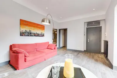 a living room with a pink couch and a table at Trevi area Penthouse in Rome