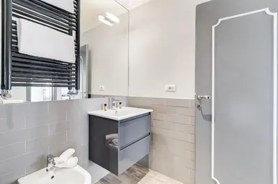 a bathroom with a sink and a toilet and a mirror at Trevi area Penthouse in Rome