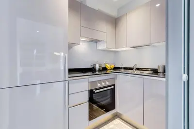 a white kitchen with white cabinets and an oven at Trevi area Penthouse in Rome
