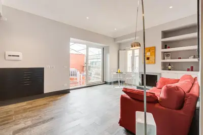 a living room with a red couch and a fireplace at Trevi area Penthouse in Rome