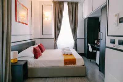 a bedroom with a bed with red pillows and a window at Royal Suite du Vatican in Rome