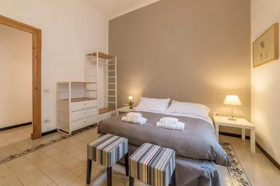 a bedroom with a large bed with two stools at Elizabeth House - WelcomeToRhome in Rome