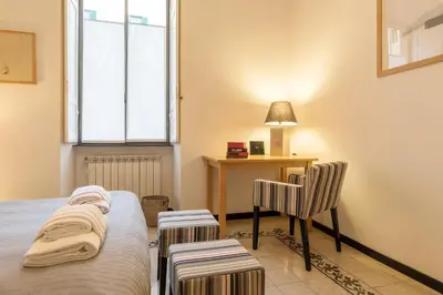 a bedroom with a bed and a desk and a chair at Elizabeth House - WelcomeToRhome in Rome