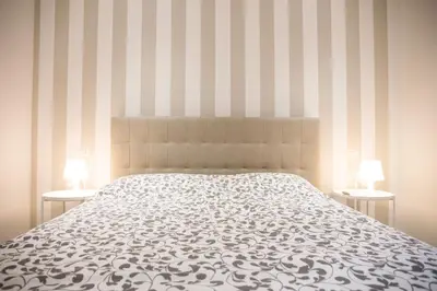 a bedroom with a bed and two tables with lamps at San Pietro Dreaming Rooms in Rome