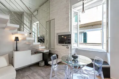 a living room with a glass table and chairs at Modern Loft Walk to St Peter IREX Apartment in Rome