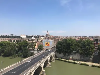 a bridge over a river with a city in the background at Modern Loft Walk to St Peter IREX Apartment in Rome