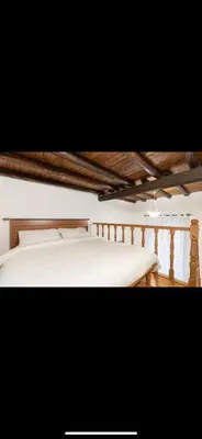 a bedroom with a white bed with a wooden ceiling at IN FRONT OF COLISEUM 3 in Rome