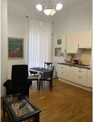 a living room with a table and a kitchen at IN FRONT OF COLISEUM 3 in Rome