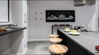 a kitchen with a counter with two stools at Moma Roma in Rome