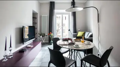a living room with a table and chairs at Moma Roma in Rome