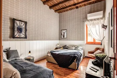 a bedroom with two beds and a tv in it at Colosseo Miracle Suite in Rome