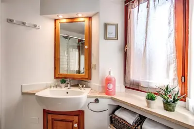 a bathroom with a sink and a mirror and a window at Colosseo Miracle Suite in Rome