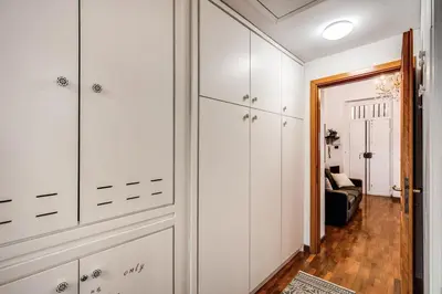 a hallway with white cabinets and a living room at Colosseo Miracle Suite in Rome