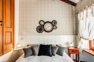 a bedroom with a bed with clocks on the wall at Colosseo Miracle Suite in Rome