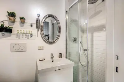a white bathroom with a sink and a shower at Colosseo Miracle Suite in Rome