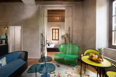 a living room with a couch and a chair at Palm Suites - Small Luxury Hotels of the World in Rome