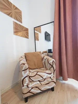 a living room with a chair and a curtain at Romerooms Cola di Rienzo in Rome