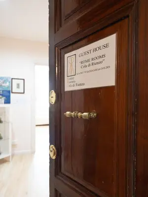 a sign on a wooden door with a sign on it at Romerooms Cola di Rienzo in Rome