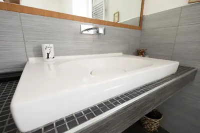 a white bath tub in a bathroom with a mirror at Romerooms Cola di Rienzo in Rome