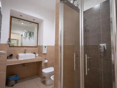a bathroom with a shower and a toilet and a sink at Romerooms Cola di Rienzo in Rome