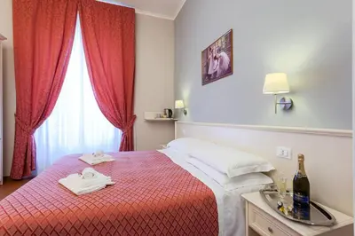 a bedroom with a red bed with two towels on it at Ottaviano Guest House in Rome