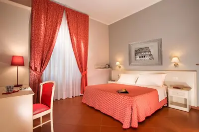 a bedroom with a bed and a chair and a window at Ottaviano Guest House in Rome