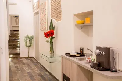 a kitchen with a counter with a vase of red flowers at Guesthouse MySuiteTower Pantheon in Rome