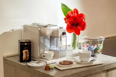 a counter with a coffee maker and cups and a flower at Guesthouse MySuiteTower Pantheon in Rome