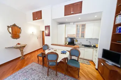 a living room with a table and chairs and a kitchen at A CASA DI ZIA LOLA in Rome