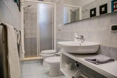 a white bathroom with a sink and a toilet at Vatican Jewel Apartment in Rome