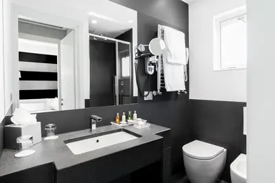 a black and white bathroom with a sink and a toilet at Hotel Mancino 12 in Rome
