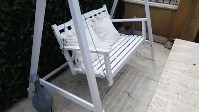 a white rocking chair with a pillow on it at Hotel Mancino 12 in Rome