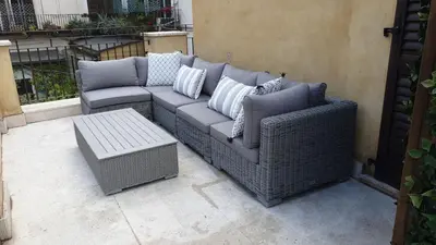 a wicker couch and a table on a patio at Hotel Mancino 12 in Rome