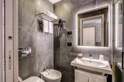 a bathroom with a sink and a toilet and a mirror at Colosseo Prestige Rooms in Rome