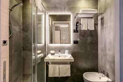 a bathroom with a sink and a toilet and a mirror at Colosseo Prestige Rooms in Rome