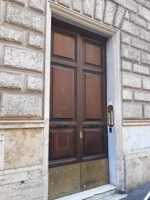 a large wooden door on the side of a building at Colosseo Prestige Rooms in Rome
