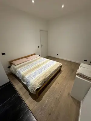 a bedroom with a bed in a white room at Alloggio Roma Appia in Rome