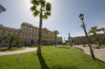 a palm tree in a park in front of a building at Ara Pacis Inn in Rome