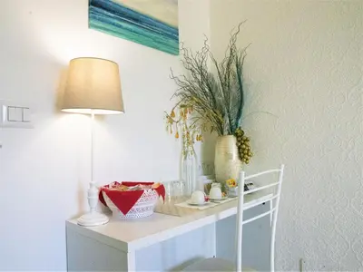 a white table with a lamp and flowers on it at B&B Dea Tiburtina in Rome